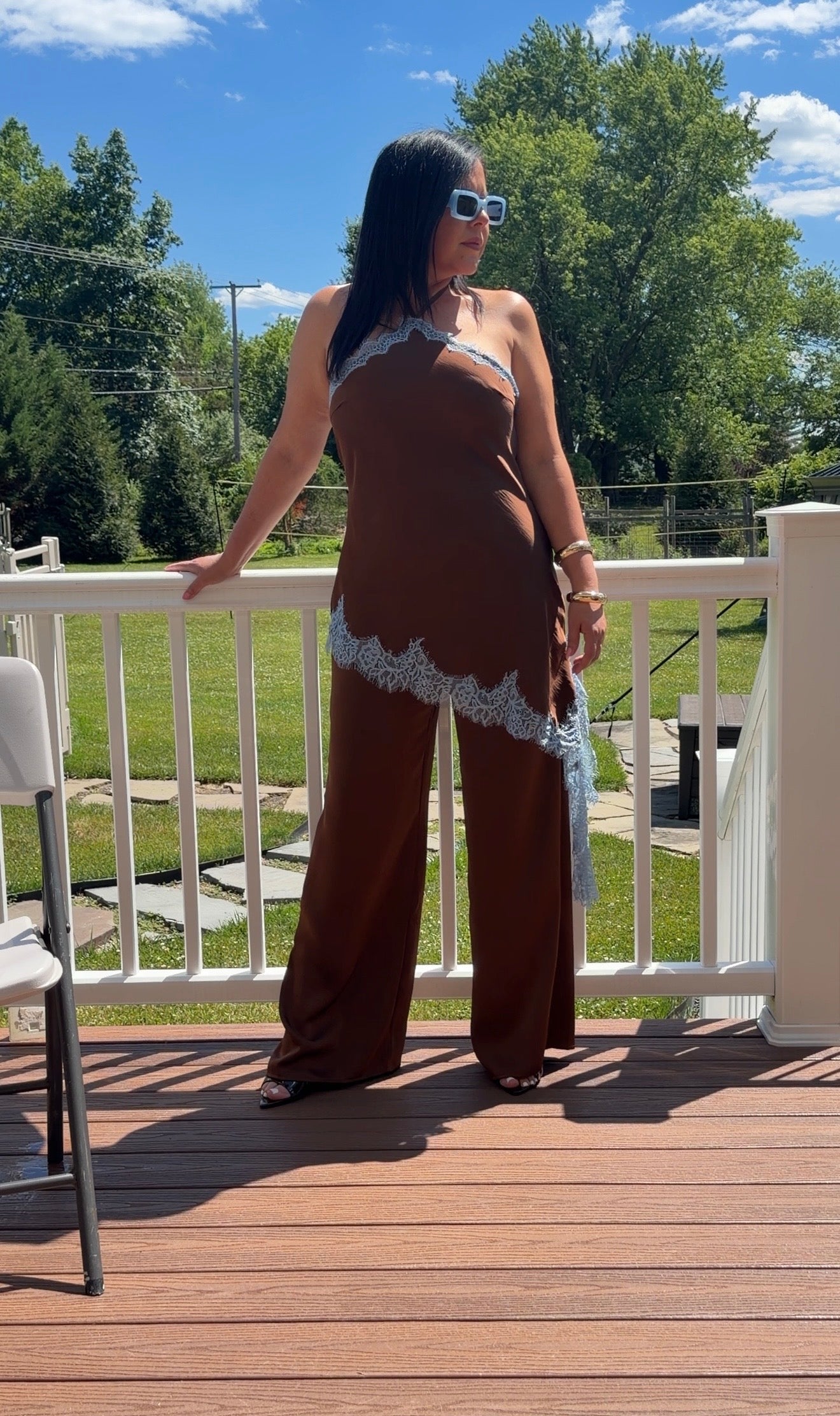 Chocolate brown satin halter jumpsuit with asymmetrical lace trim, front view"